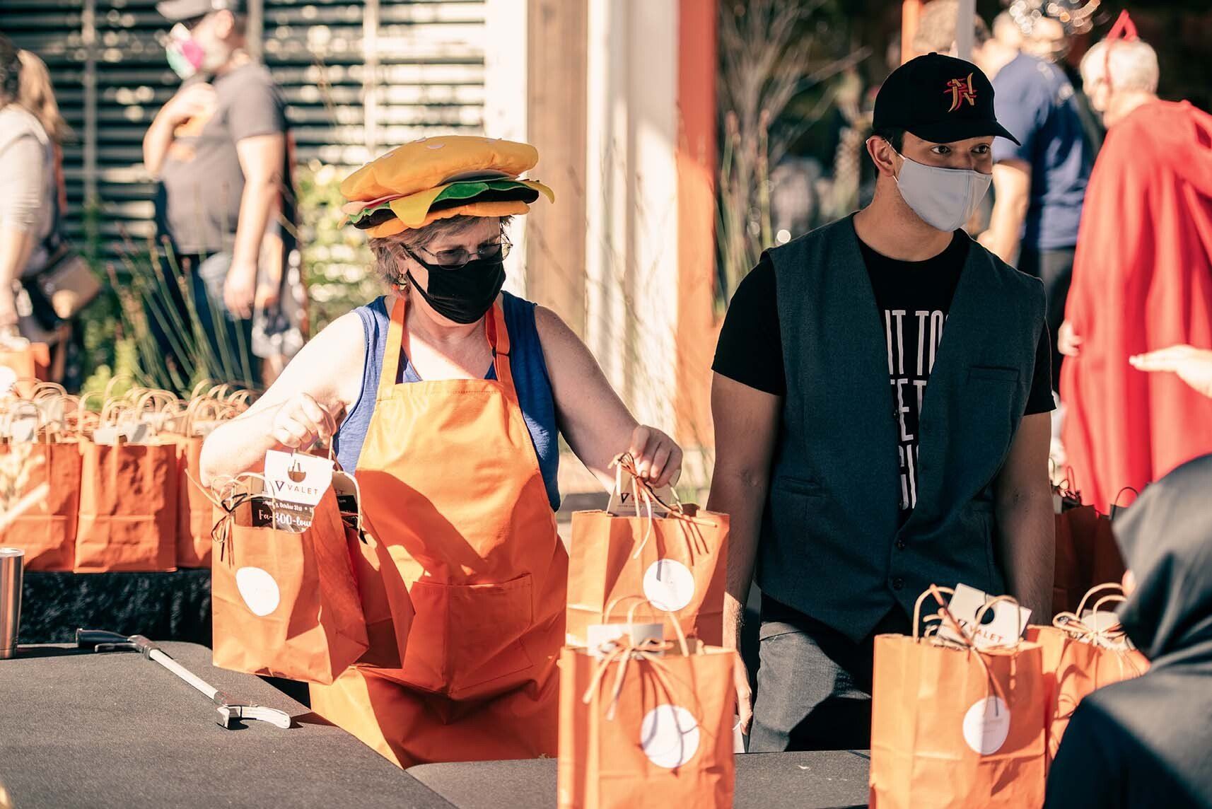 A man and a woman wearing face masks are standing next to each other.