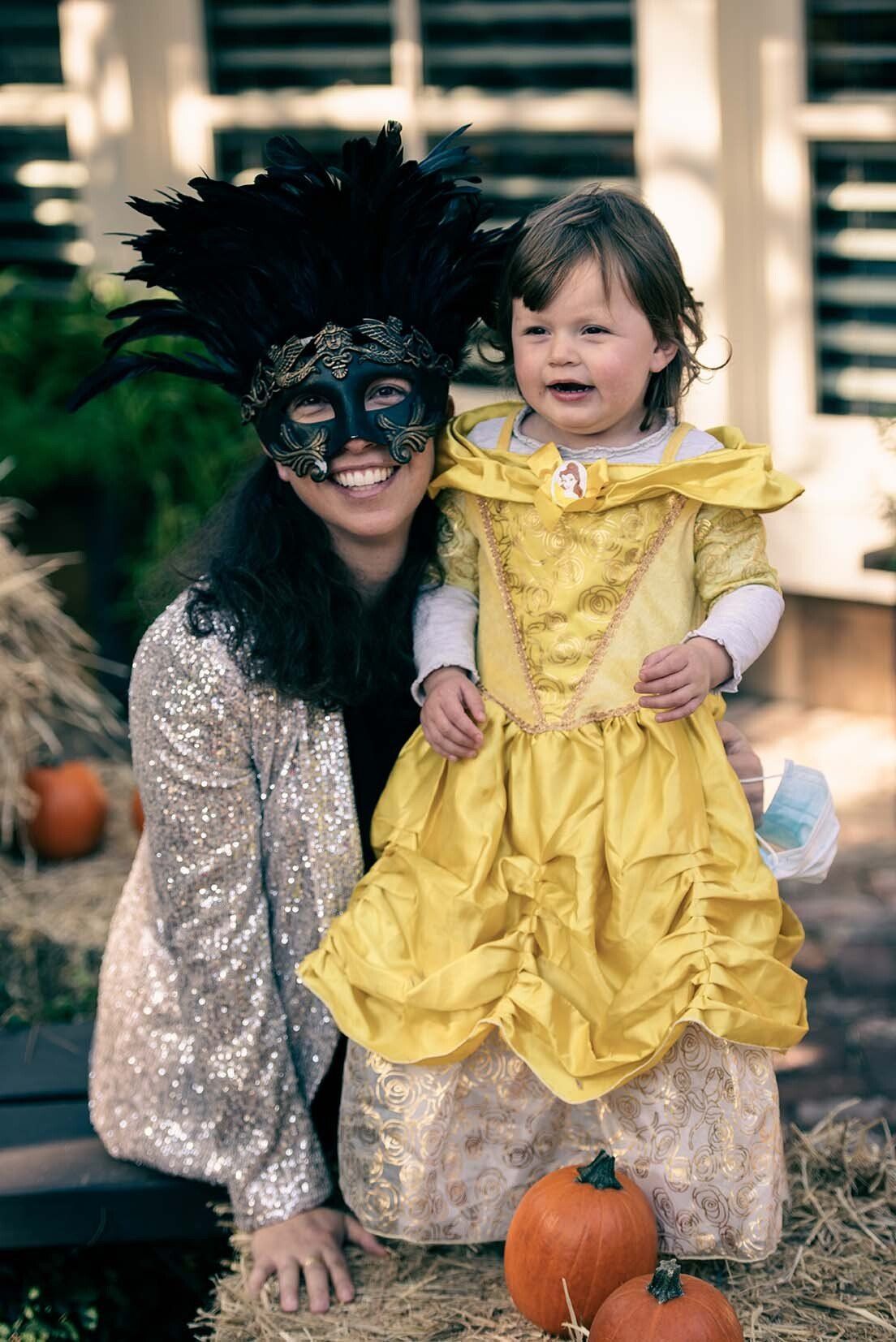 A woman and a little girl in costumes are posing for a picture.