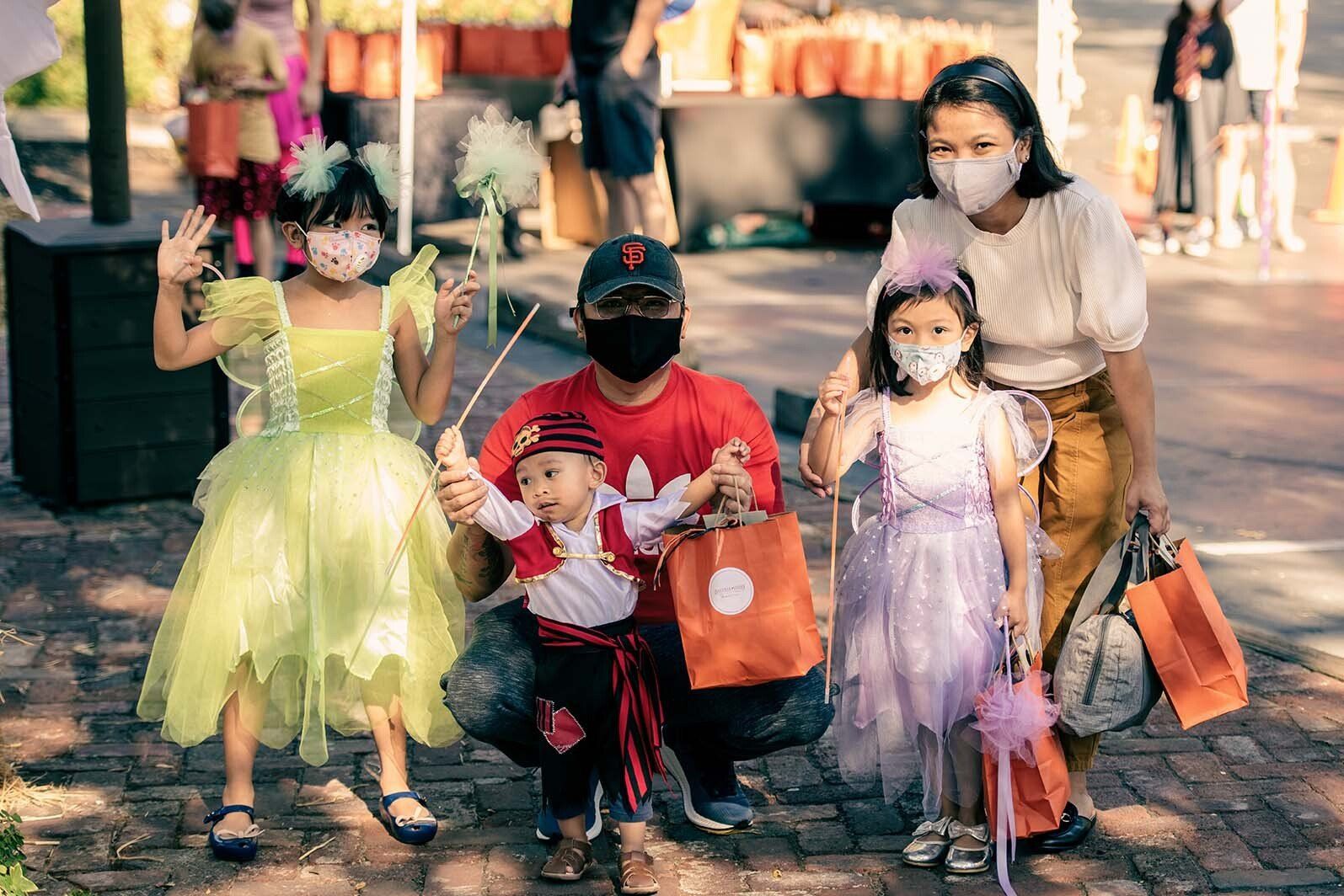 A family wearing masks and costumes is posing for a picture.