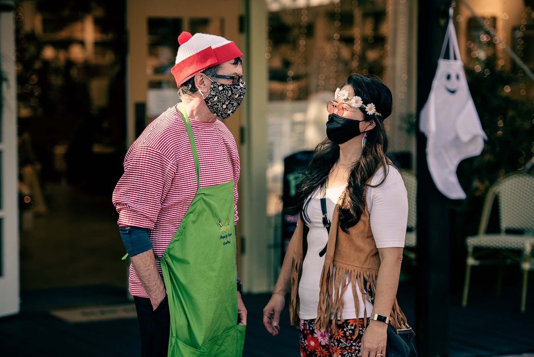 A man and a woman wearing masks are standing next to each other.