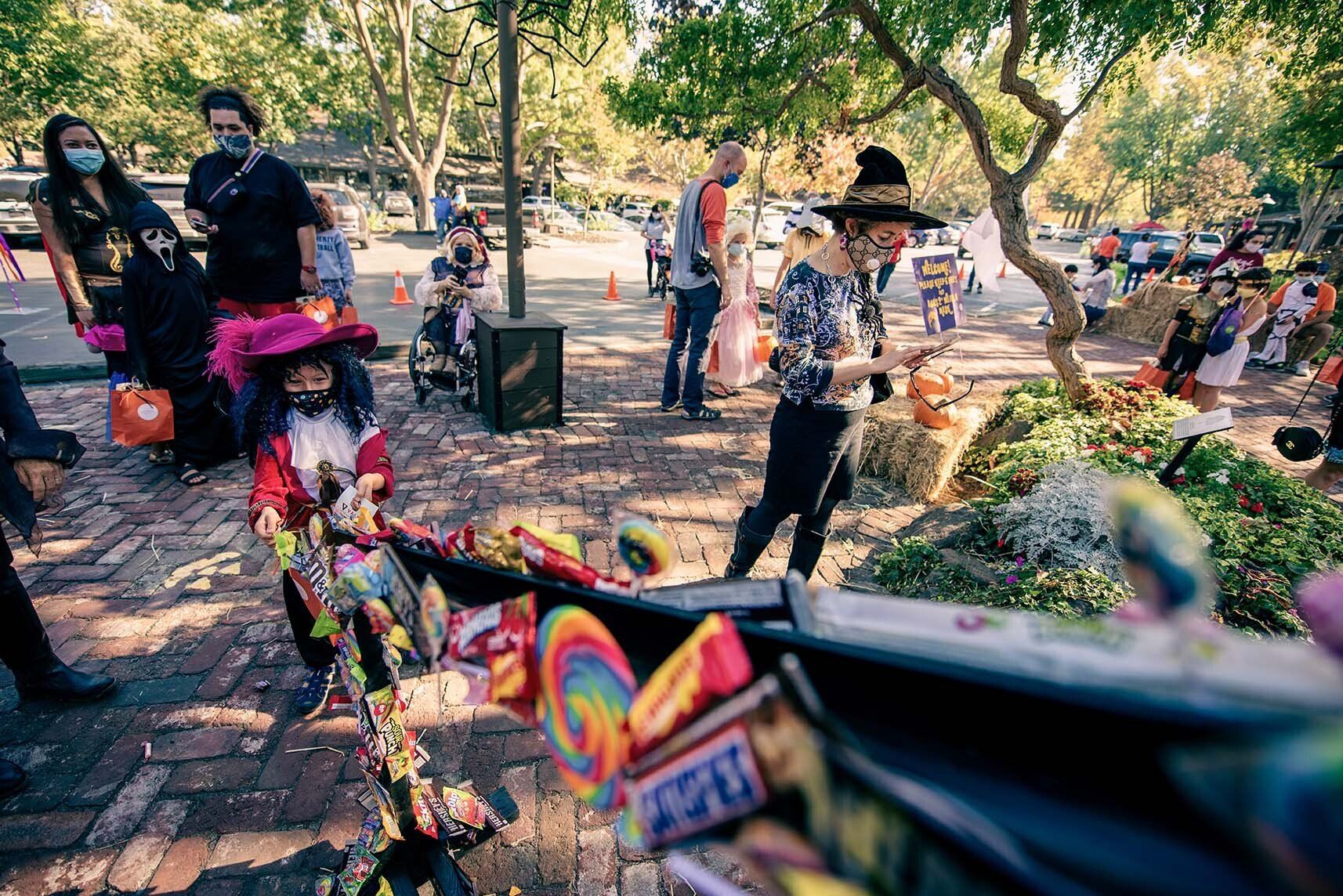 A group of people are standing around a pile of candy.