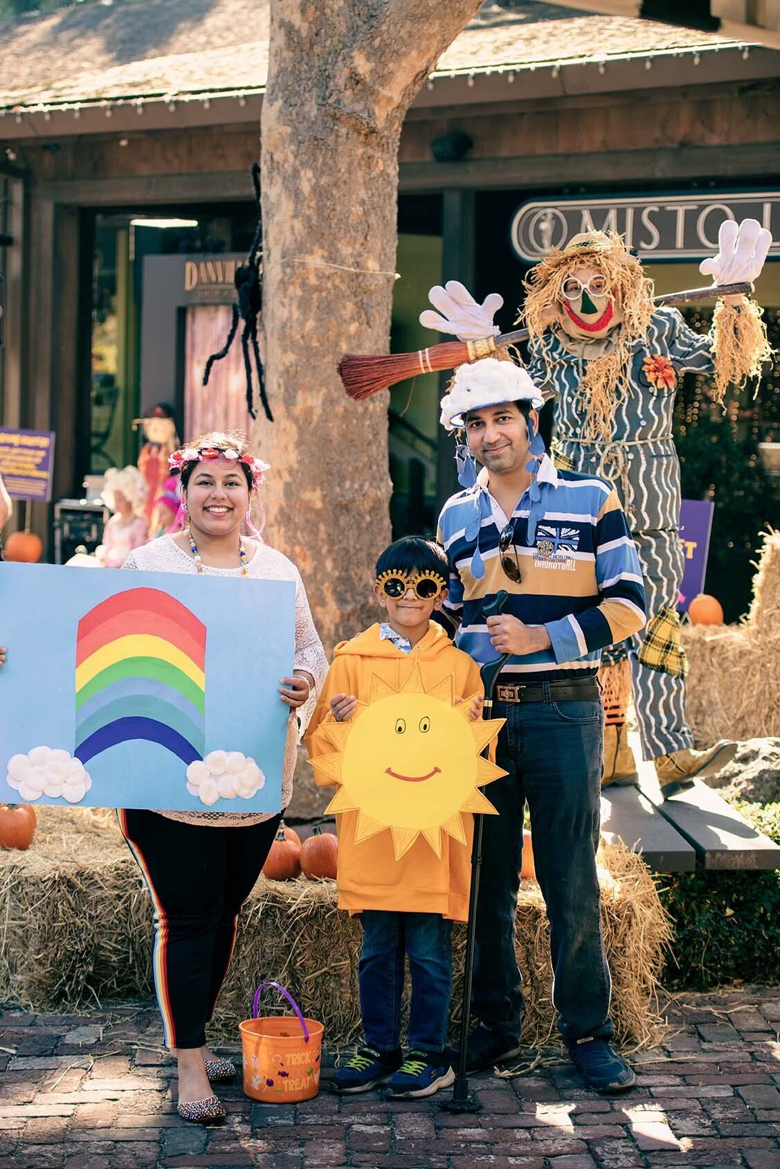A family is posing for a picture with a rainbow and a sun.