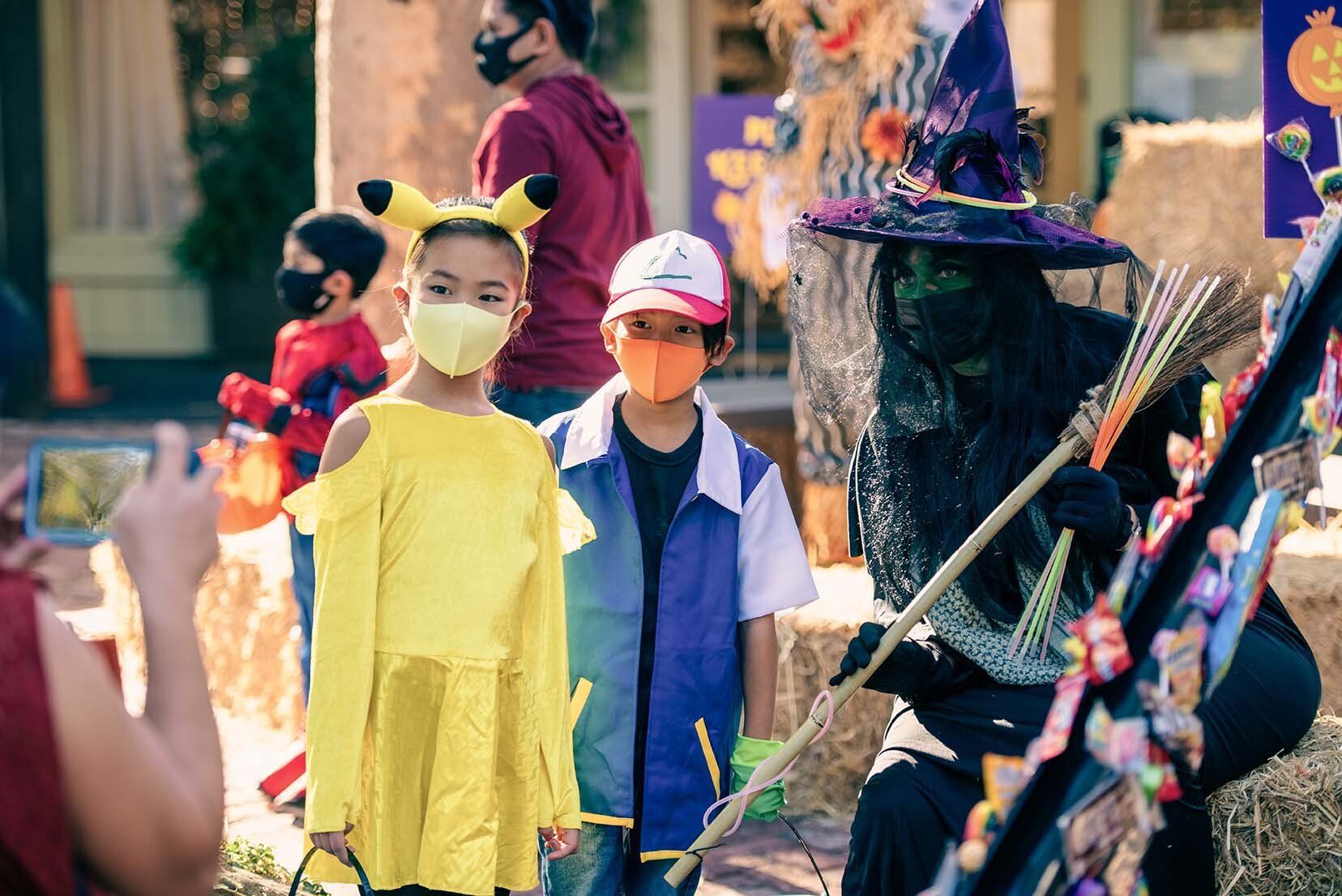 A man is taking a picture of a group of children in halloween costumes.