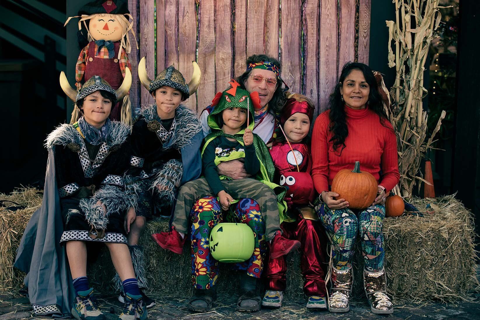 A family dressed in costumes for halloween is posing for a picture.