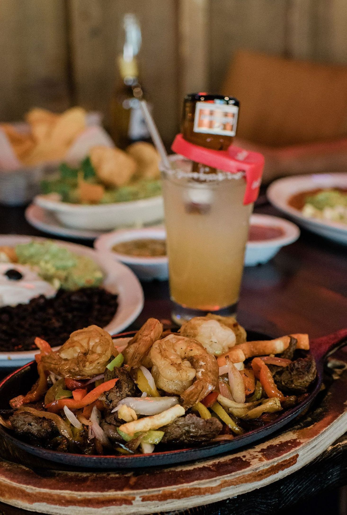 A plate of food and a glass of beer on a table.