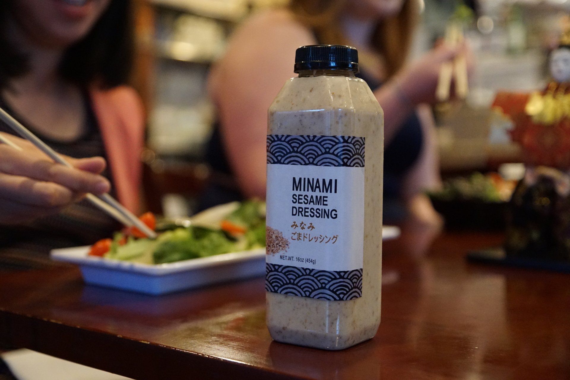 A bottle of sesame dressing is sitting on a table