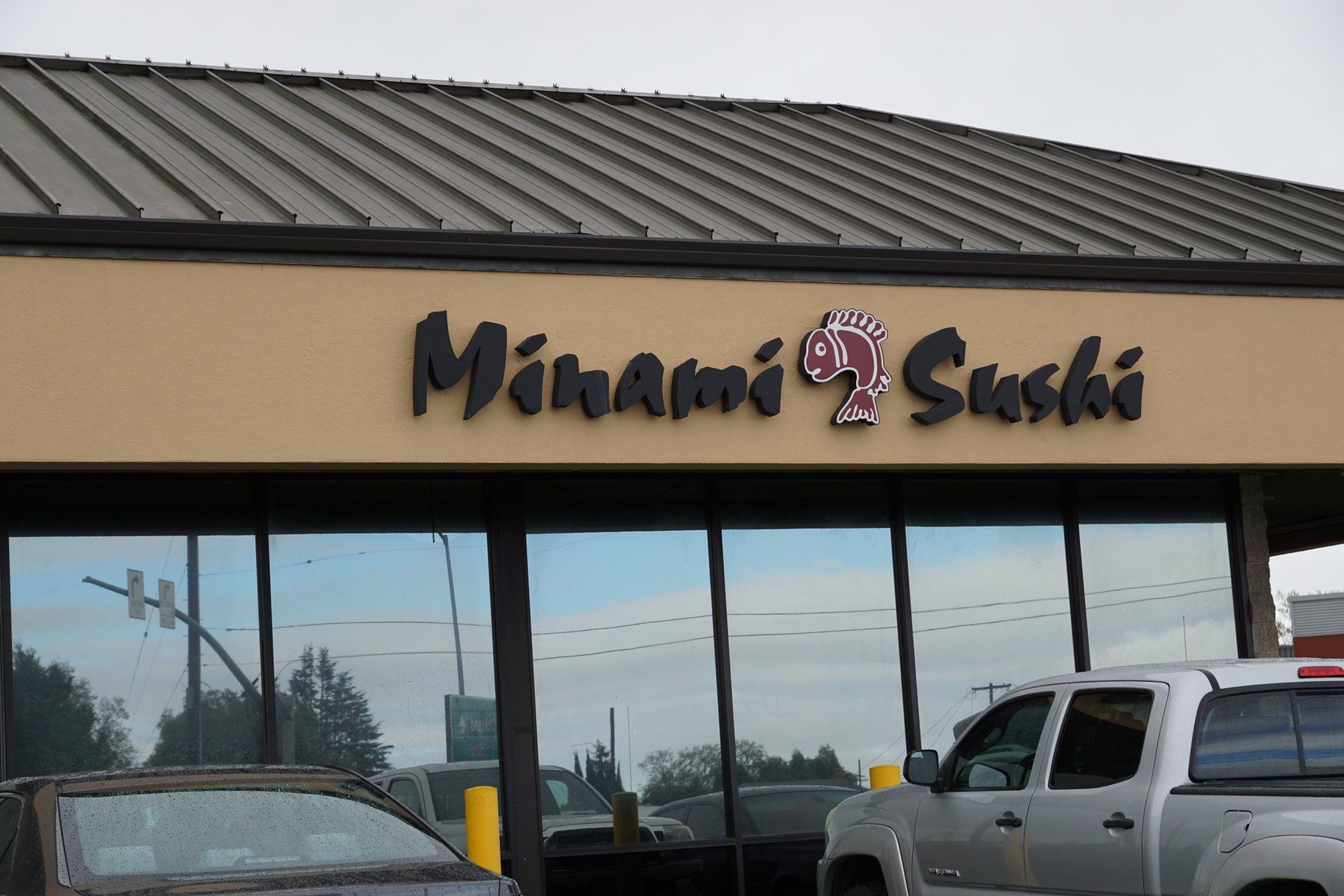 A minami sushi restaurant with a truck parked in front of it