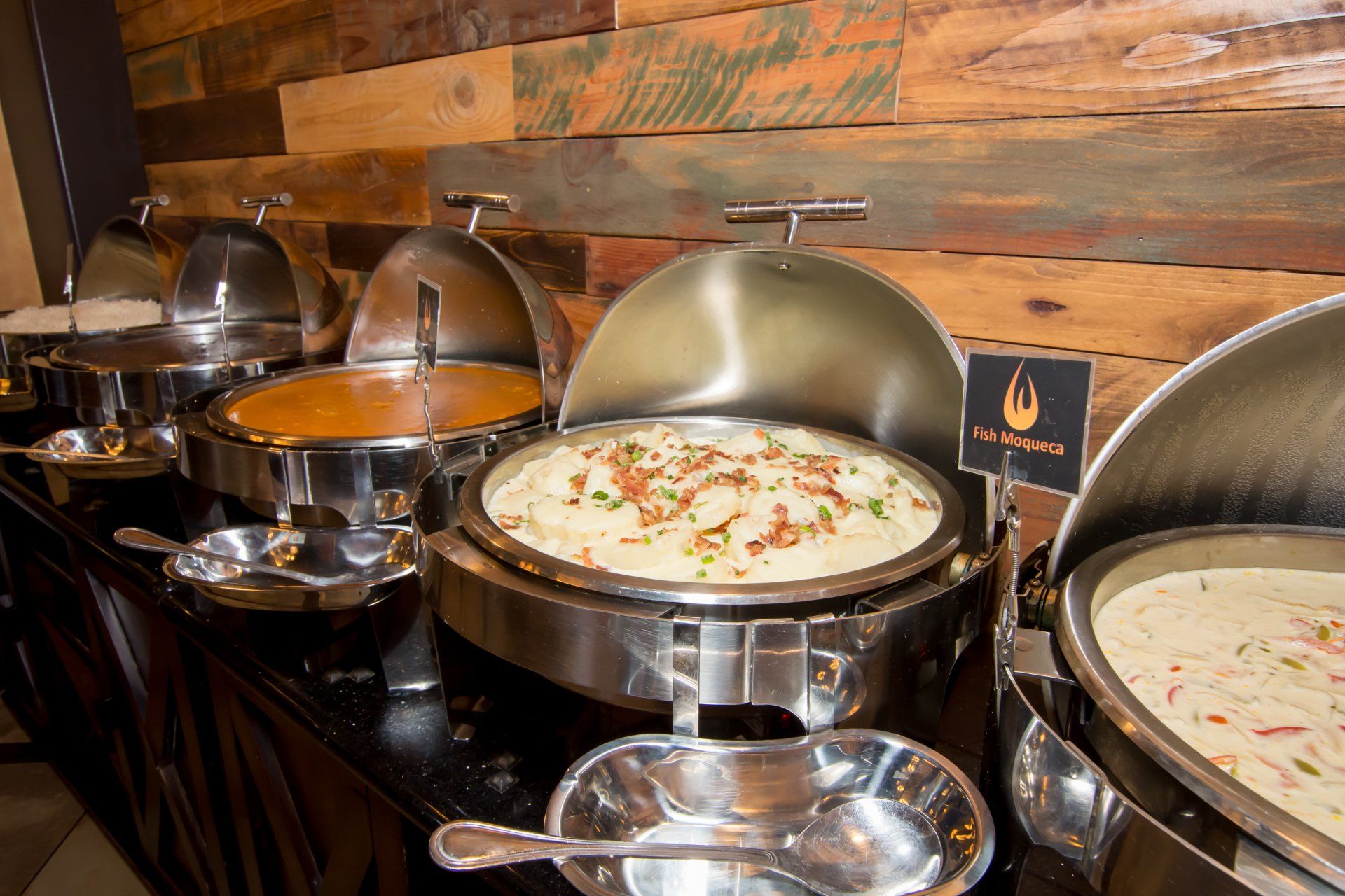 There are many different types of food on the buffet table.