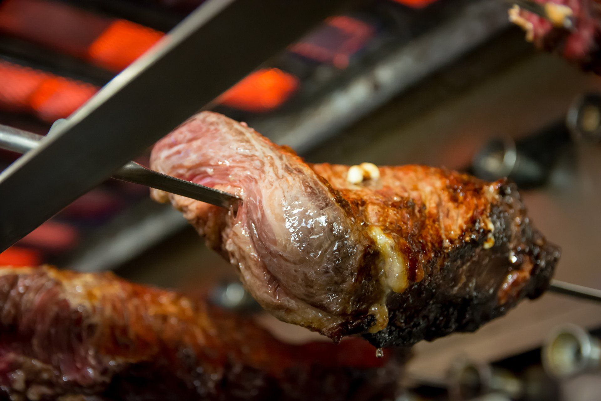 A piece of meat is being skewered on a grill.