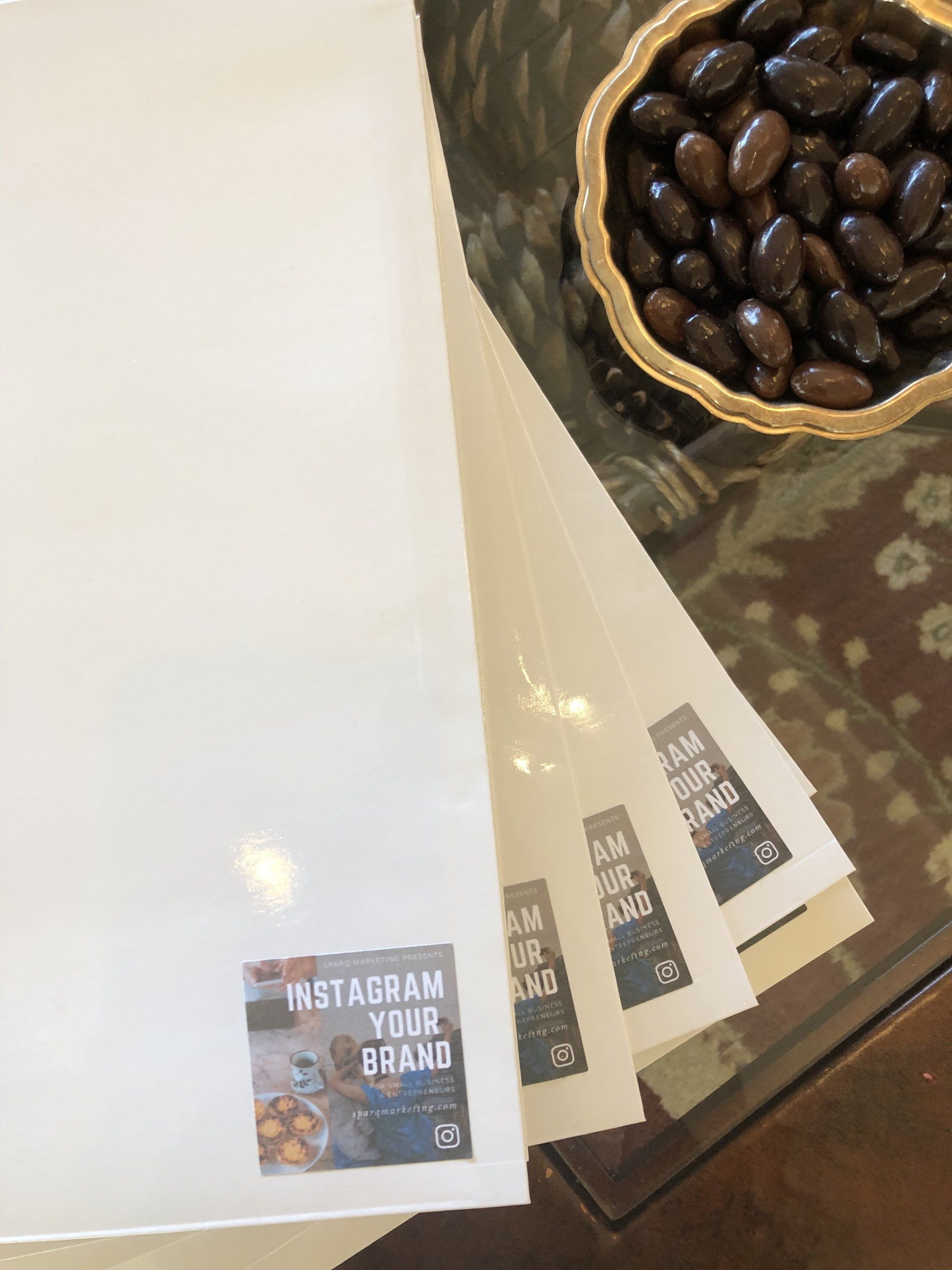 A stack of instagram your brand stickers next to a bowl of coffee beans