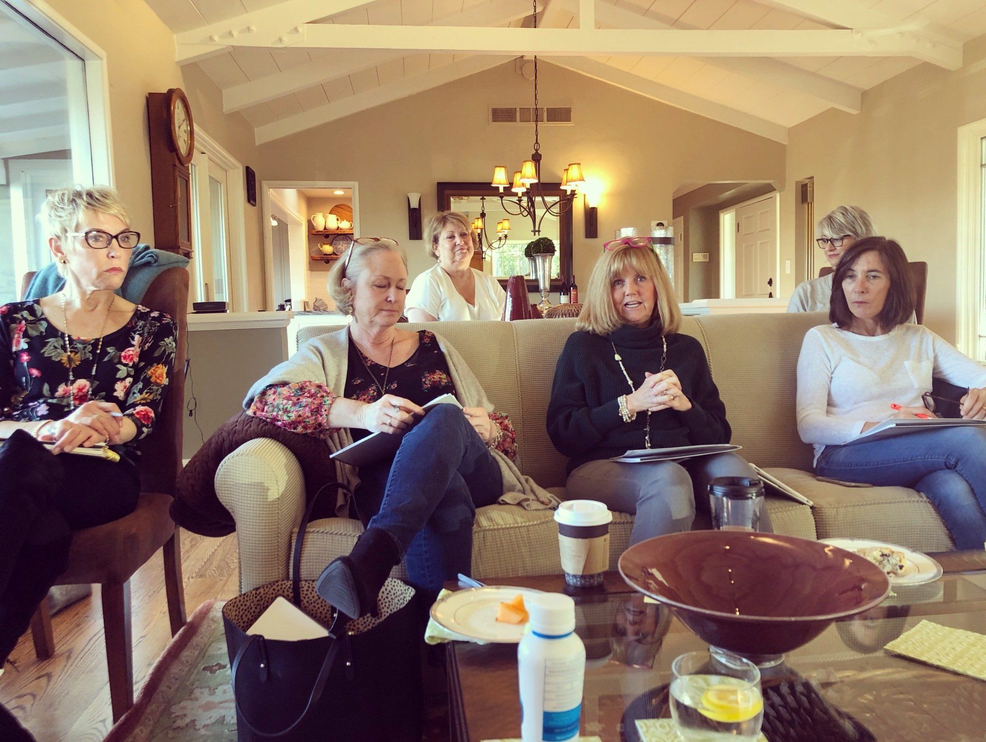 A group of women are sitting on a couch in a living room.