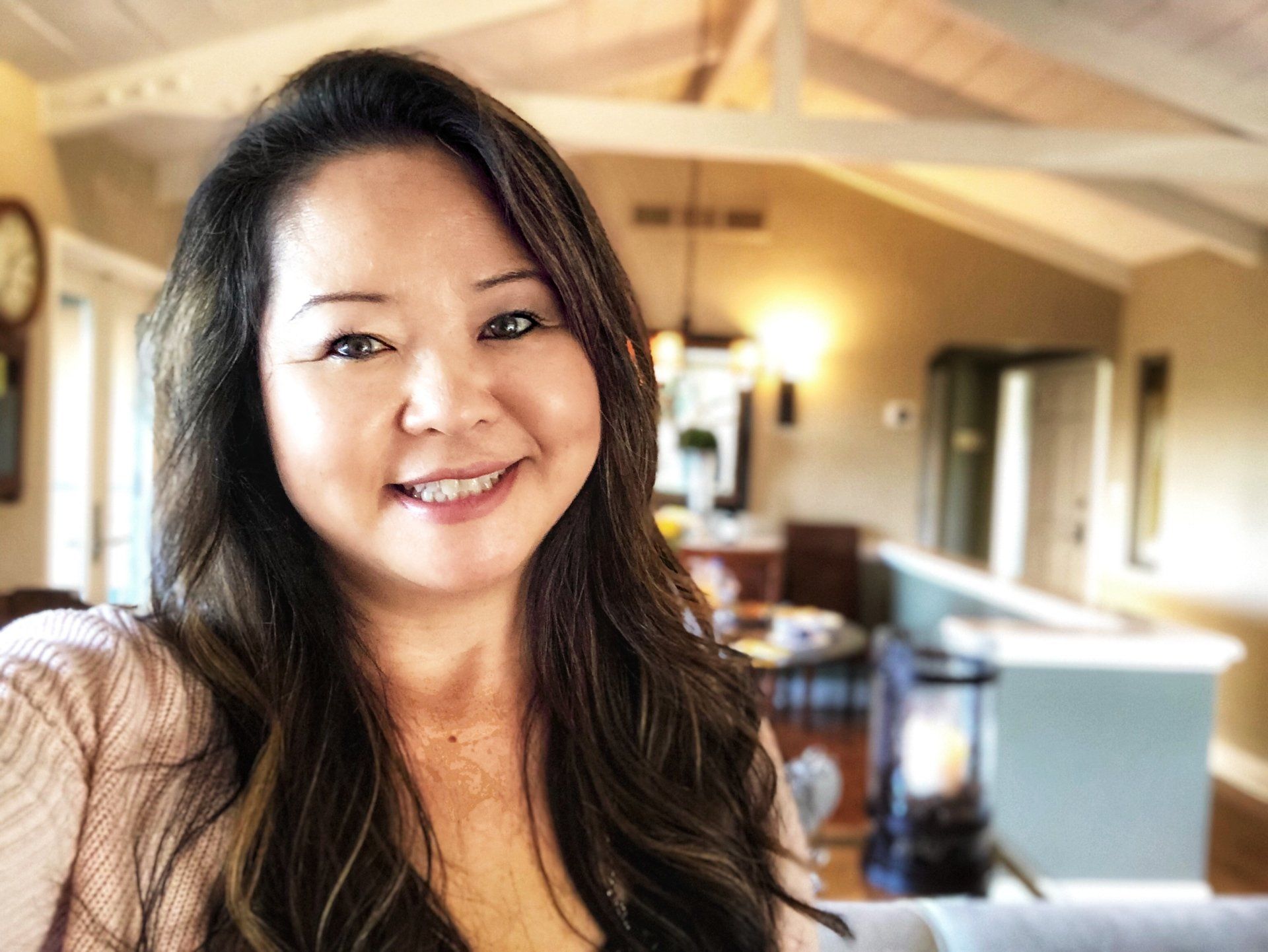 A woman is smiling for the camera in a living room.