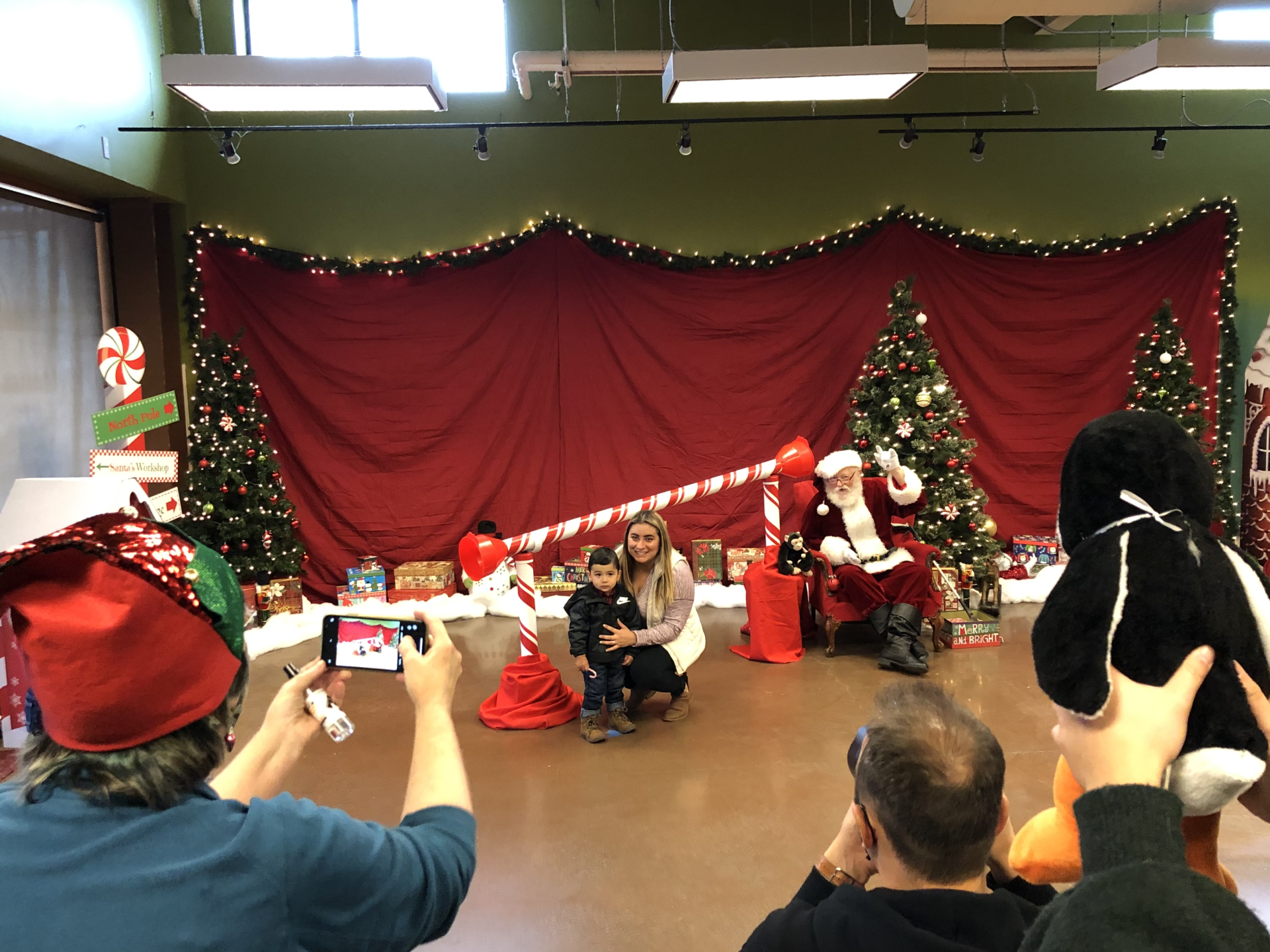 A man is taking a picture of santa claus and his family