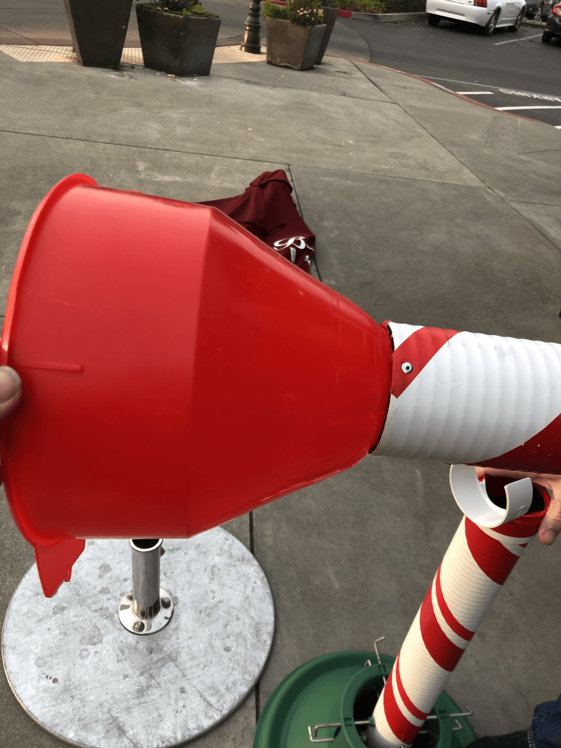 A person is holding a red and white cone in their hand