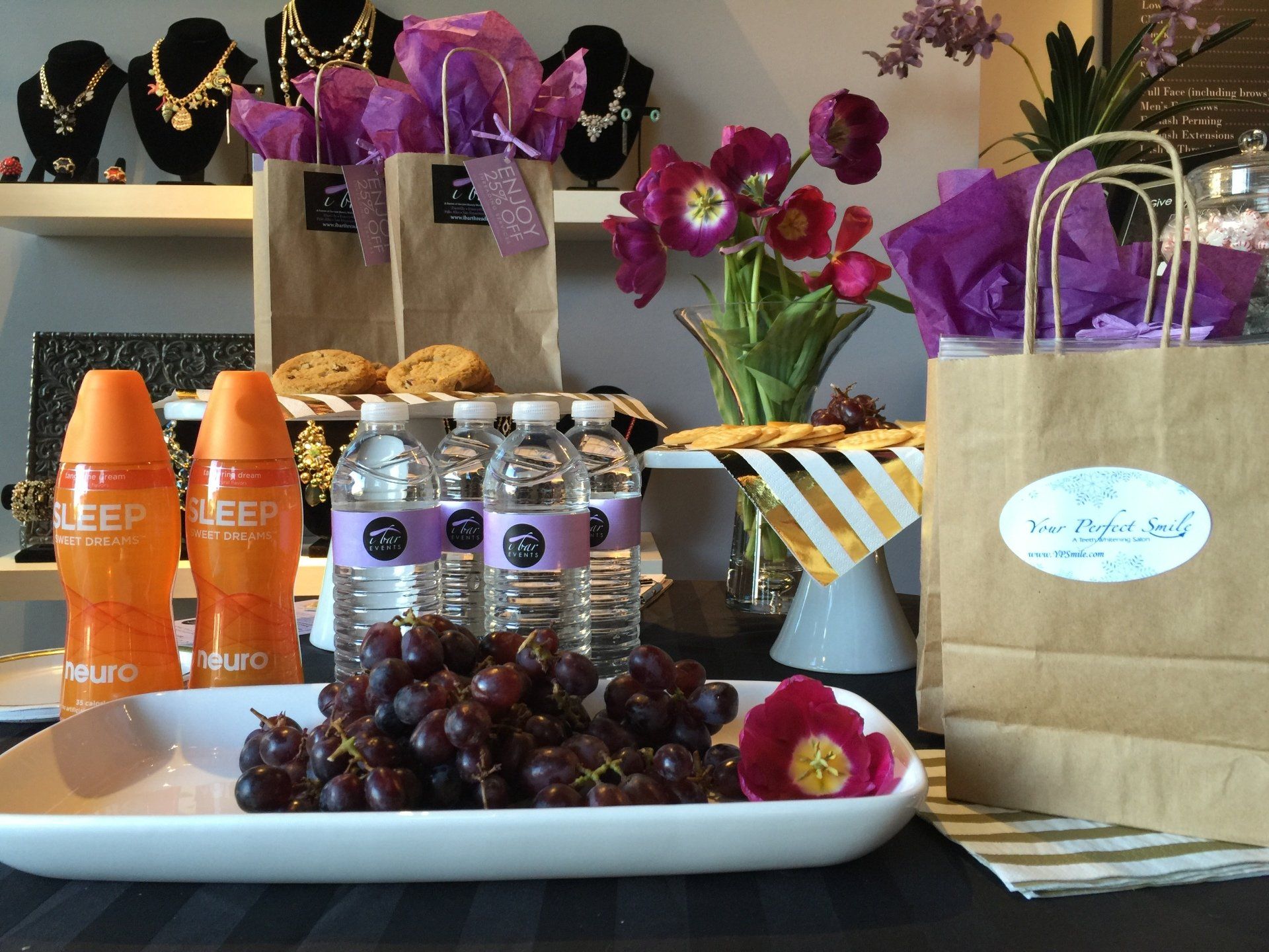 A tray of grapes sits on a table next to bottles of jeep deodorant