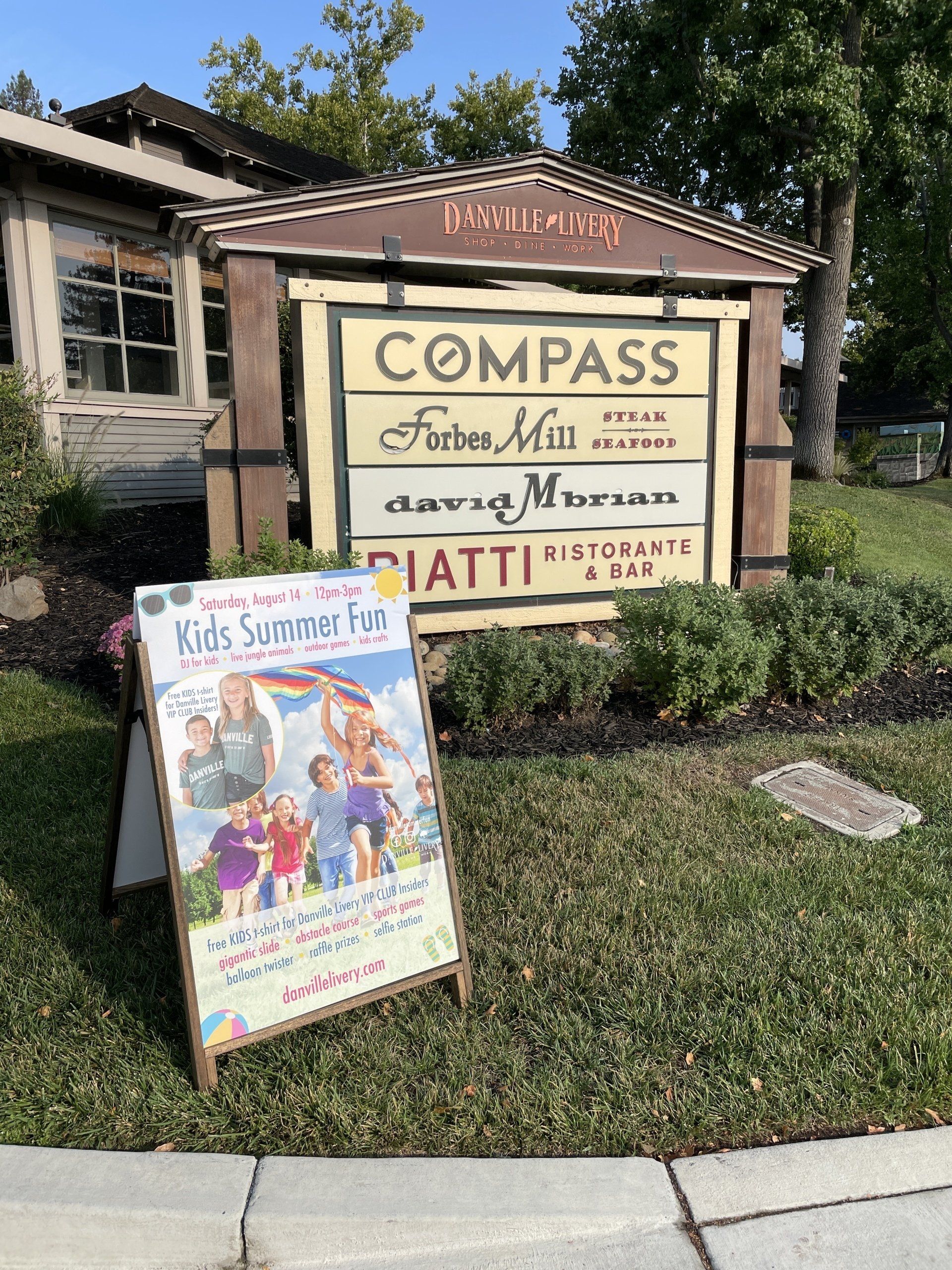 A sign that says compass is in front of a building.