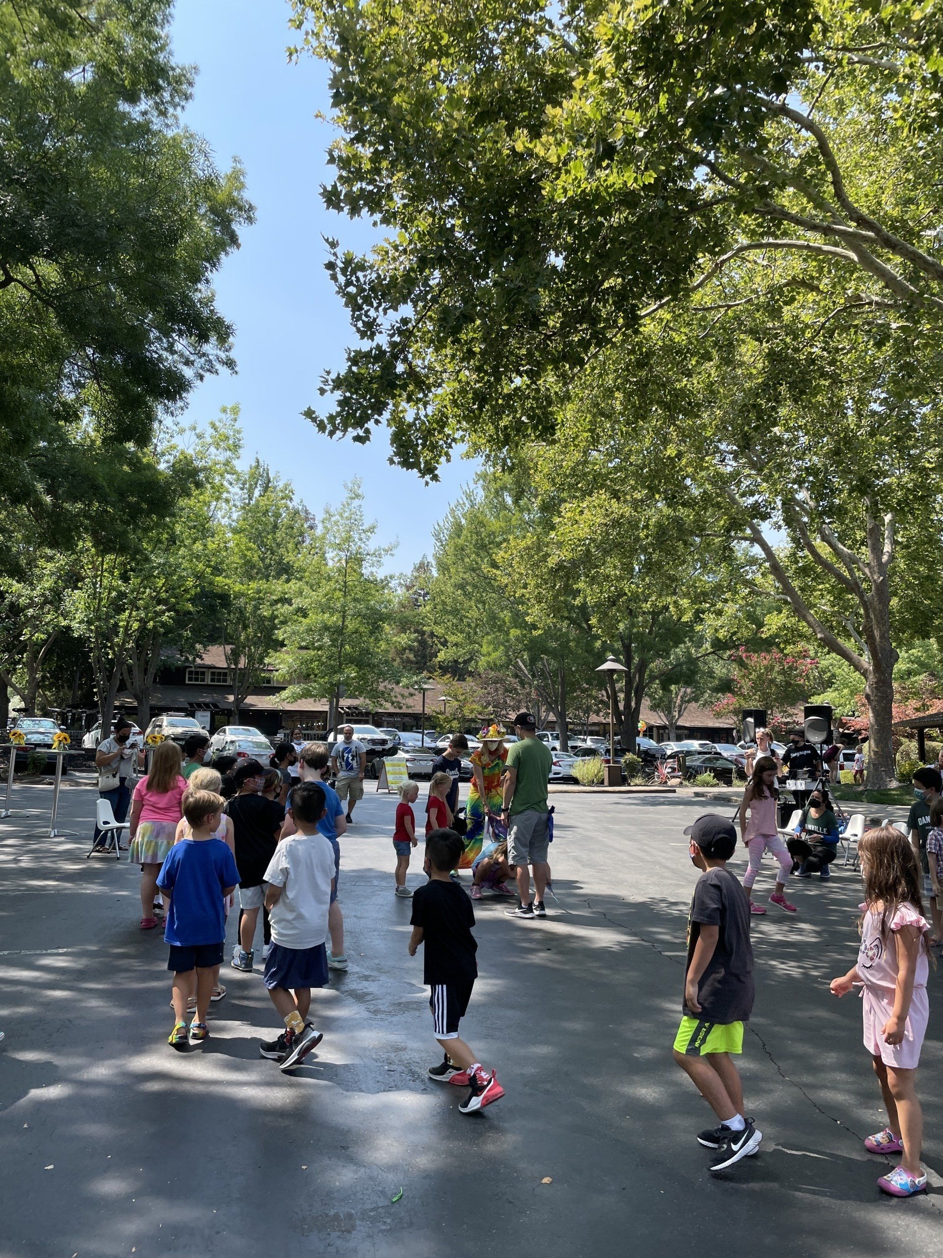 A group of children are walking down a street in a park.