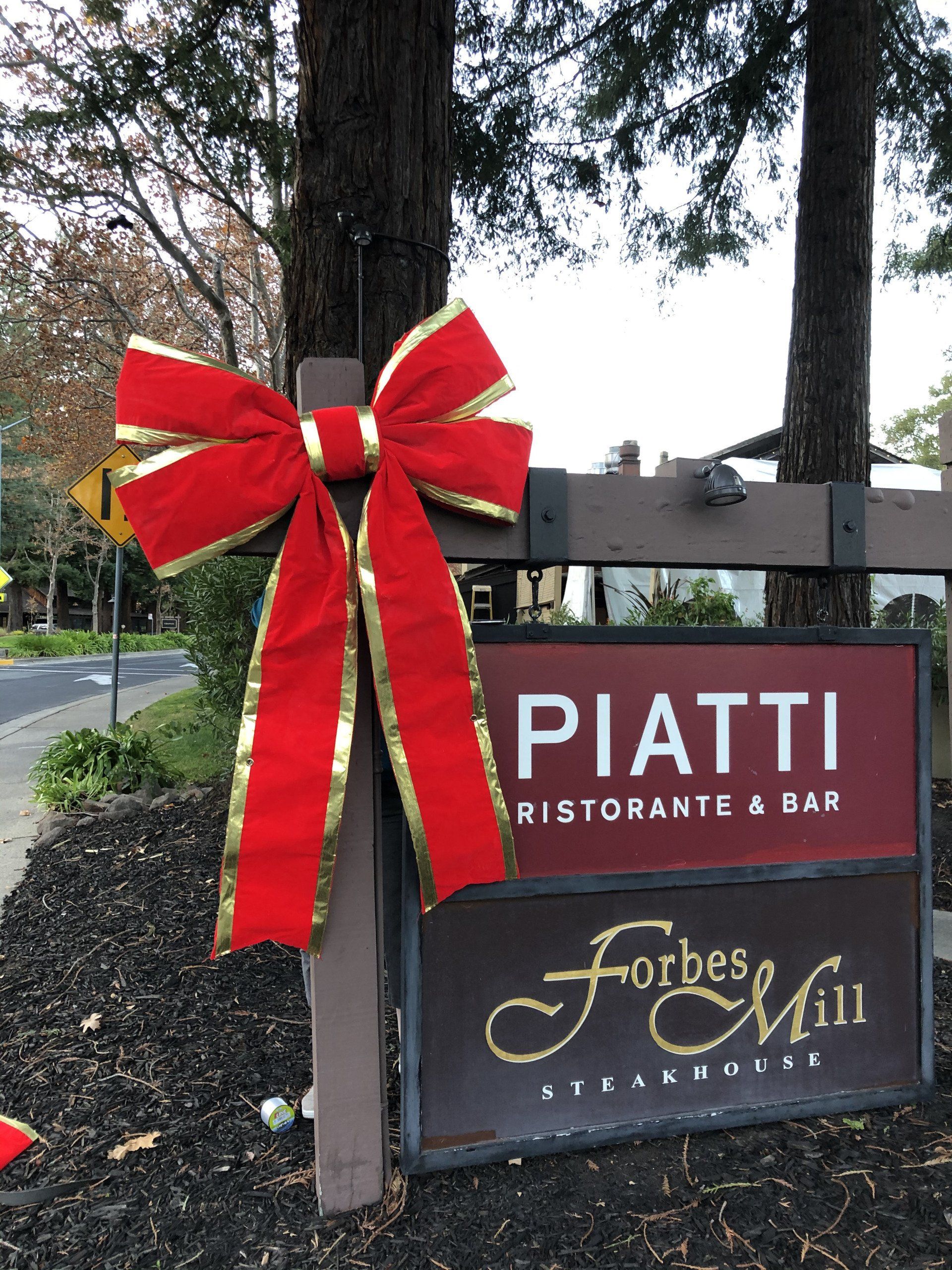 A sign for piatti ristorante and bar with a red bow