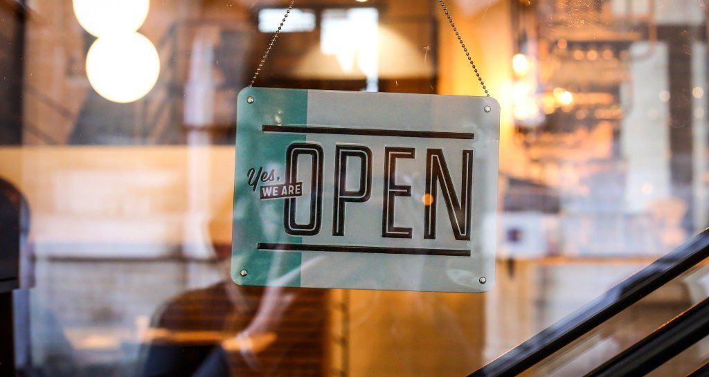 An open sign is hanging in a window of a restaurant.