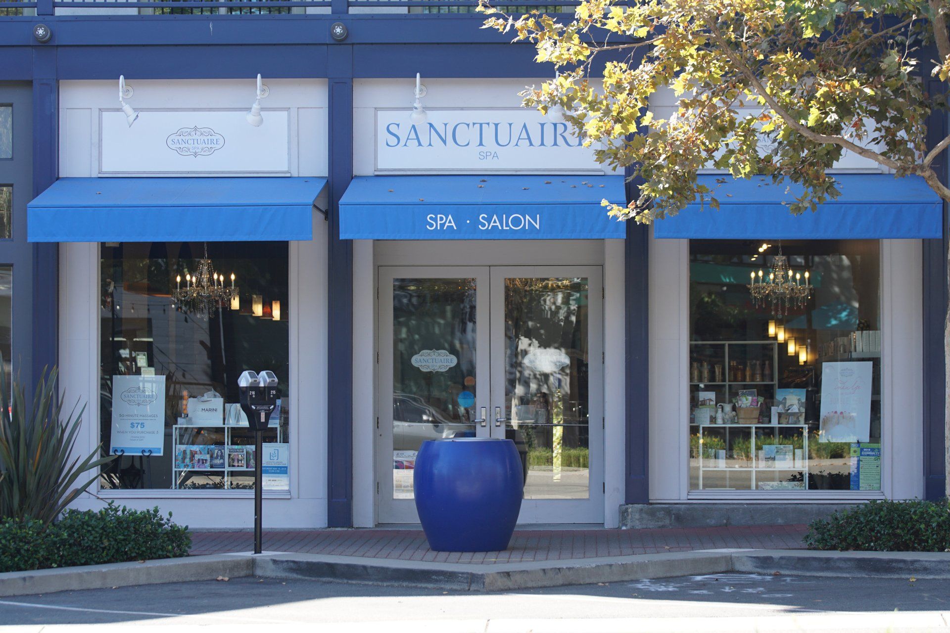 The front of a sanctuary spa salon with a blue awning