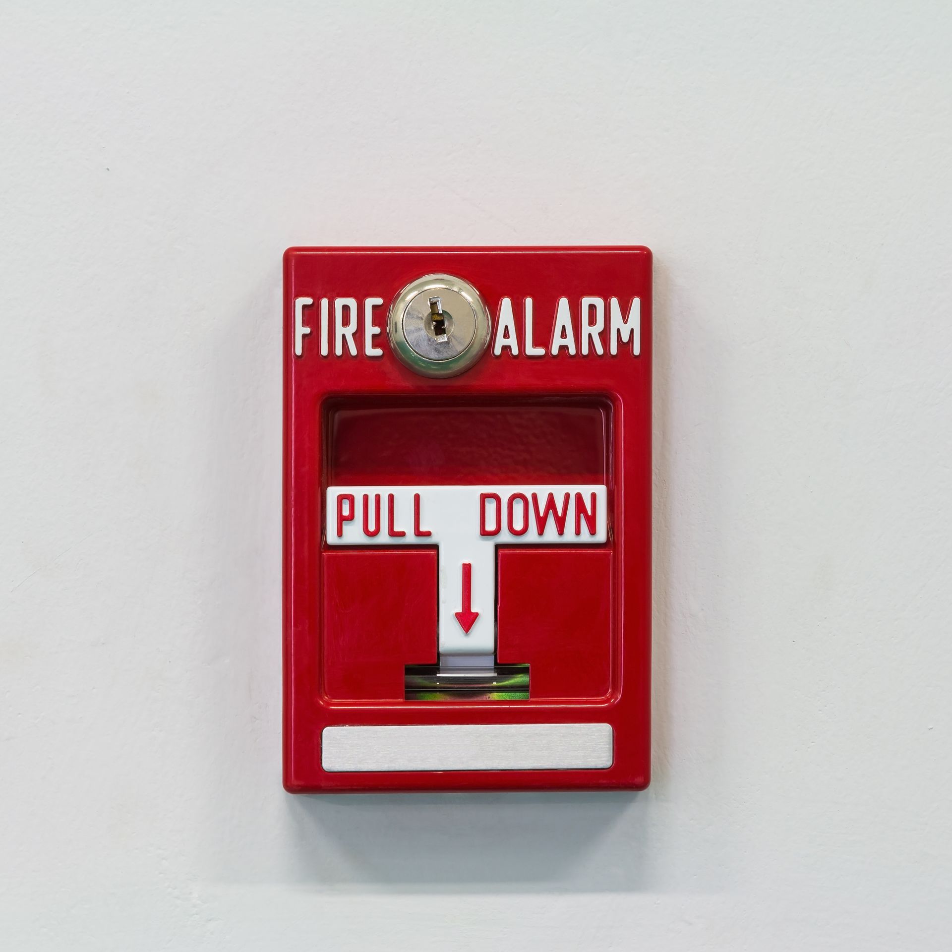 A red fire alarm is mounted on the wall, ready to alert occupants in case of emergency.
