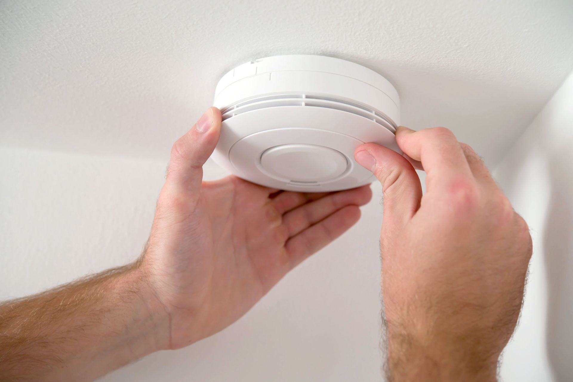 Professional man setting up advanced security alarm unit for reliable property protection.