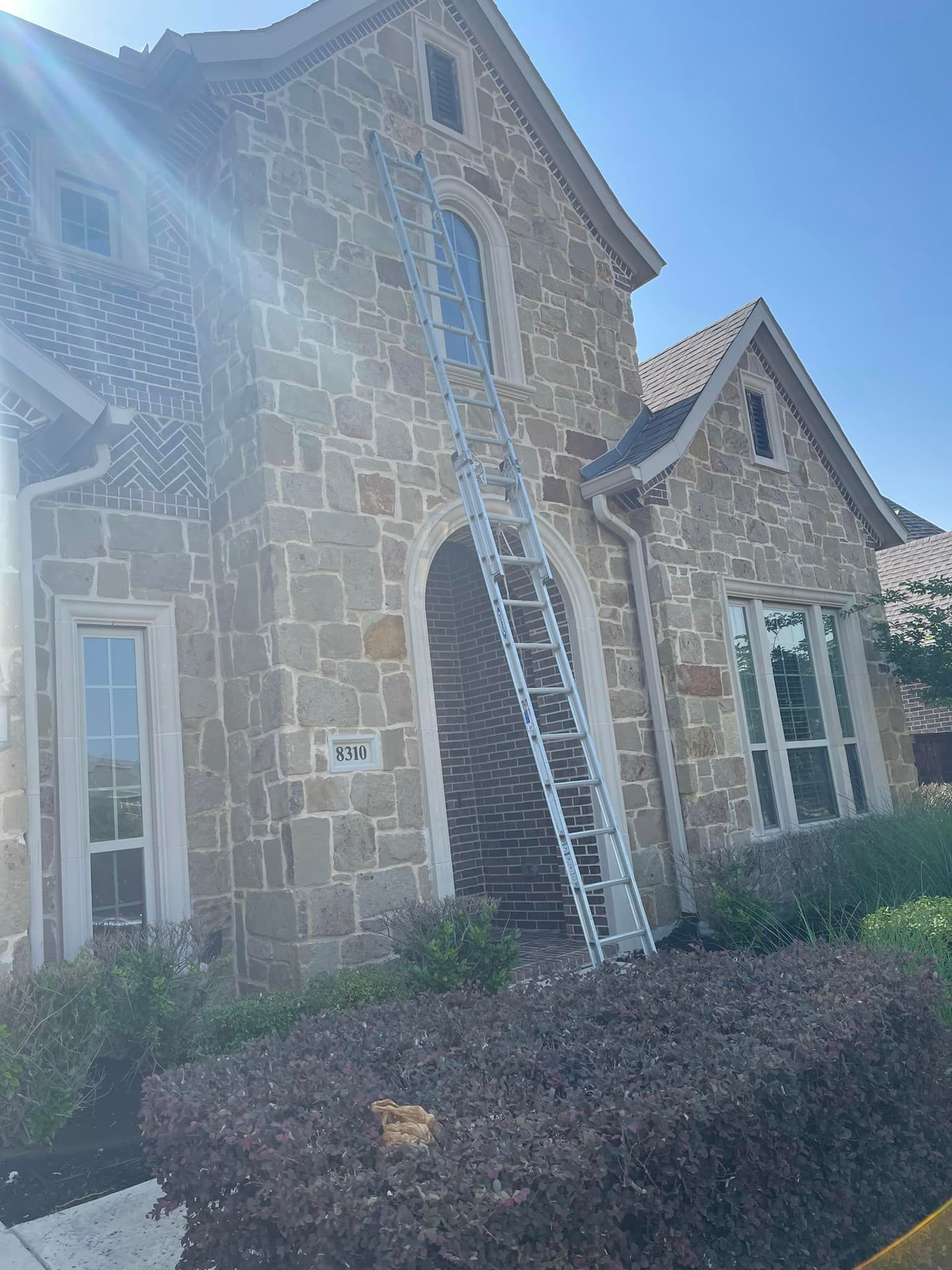 A large stone house with a ladder on the side of it.
