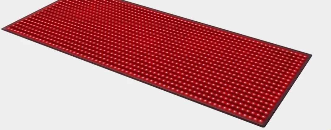 A red bar mat with a grid of small bumps on a light gray surface.