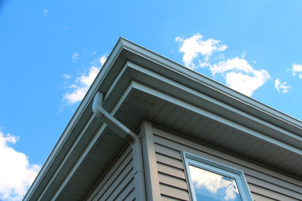 A Corner of a Beige House With Downpipe — House Guttering in Maryborough, QLD