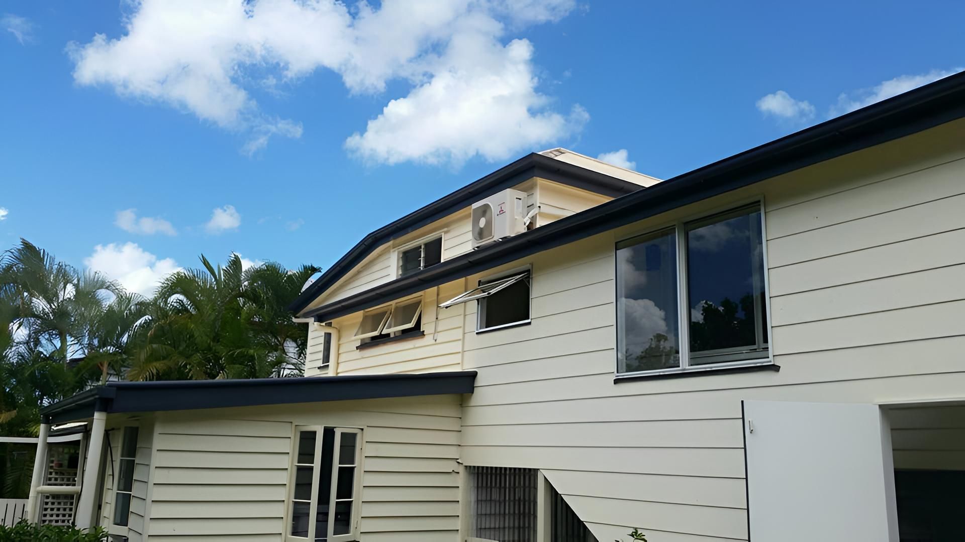 A Large White House With A Blue Sky In The Background — House Guttering in Bauple, QLD