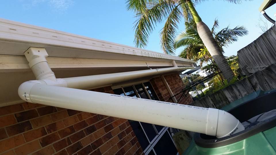 A White Pipe Is Hanging From The Roof Of A House — House Guttering Pty Ltd In Bauple, QLD