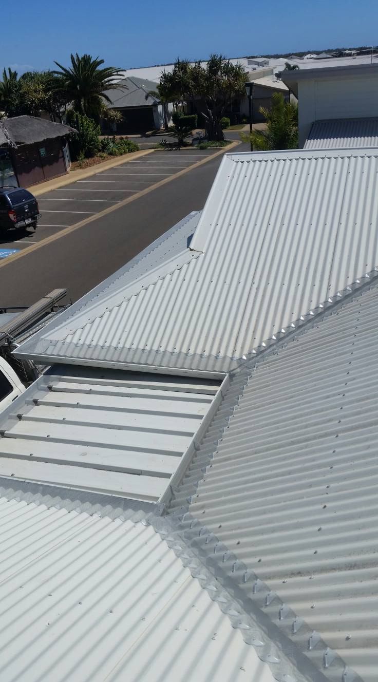 A White Corrugated Metal Roof Is Sitting On Top Of A Building — House Guttering in Bauple, QLD