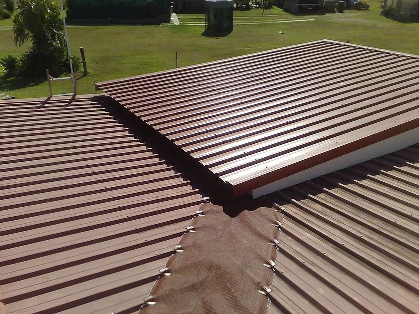 A Brown Metal Roof With A White Trim — House Guttering in Bauple, QLD