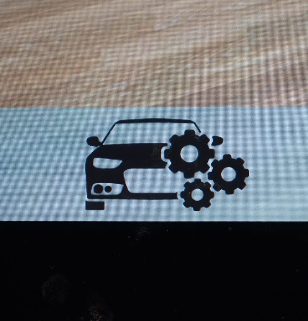 Black car silhouette with three gears, indicating a maintenance or service issue.