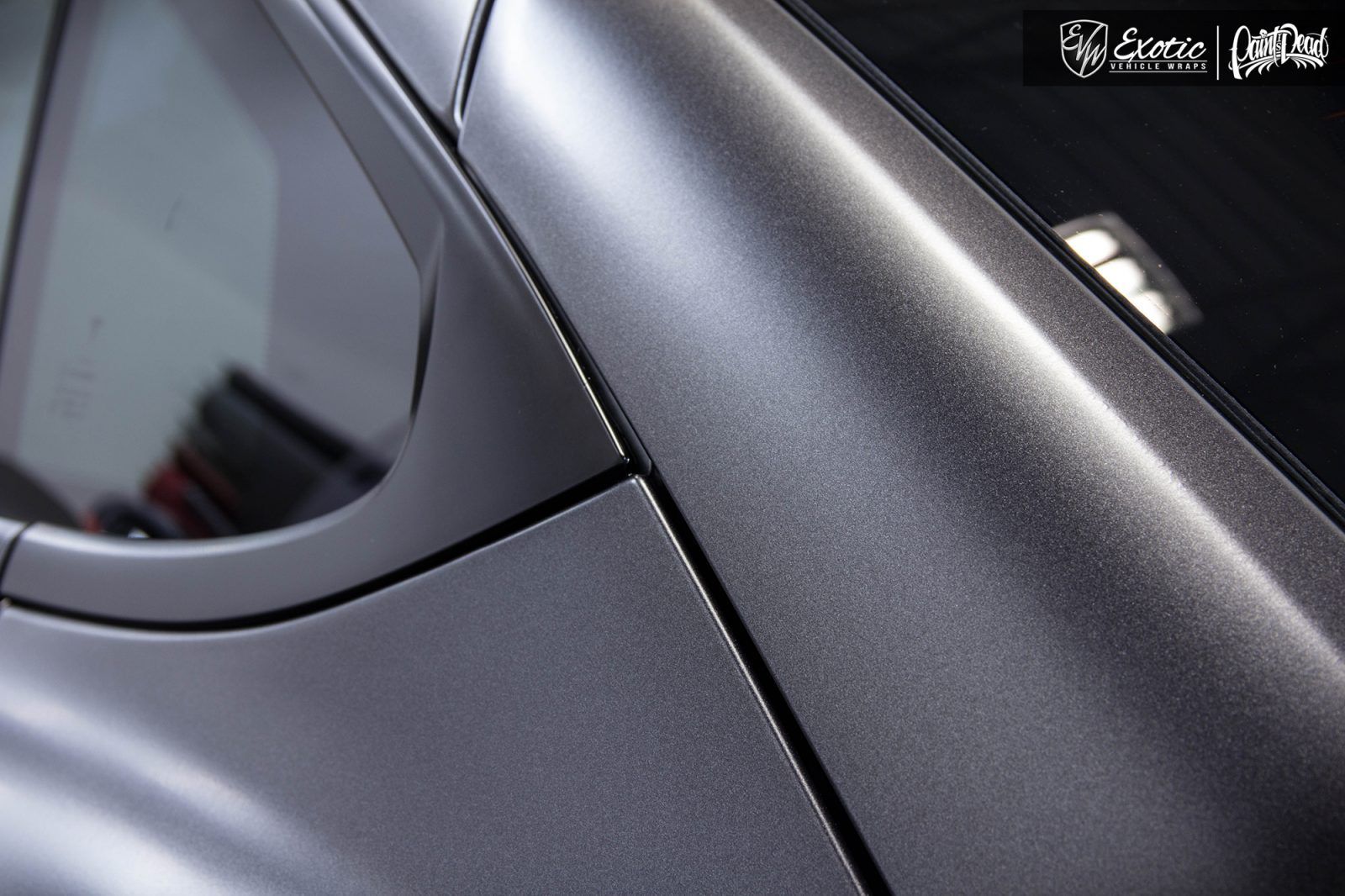 Close-up of a matte gray car surface with a slight sheen and panel lines visible.