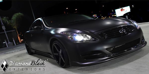 Black BMW sedan with tinted windows and black wheels.