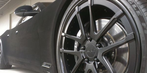 Black BMW sedan with tinted windows and black wheels.