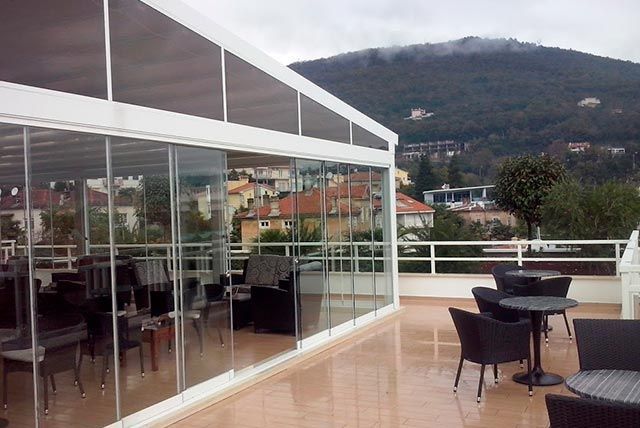 un patio con tavoli e sedie e una montagna sullo sfondo.