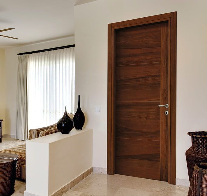 un soggiorno con una porta in legno e vasi sulla mensola