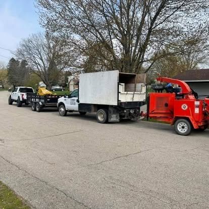 Tree service trucks and equipment parked on a residential street.