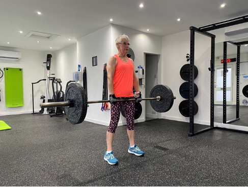 A woman picking up a barbell