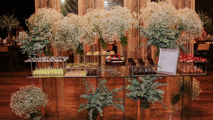 Uma mesa com flores e plantas em uma sala. Hotel Quadrado