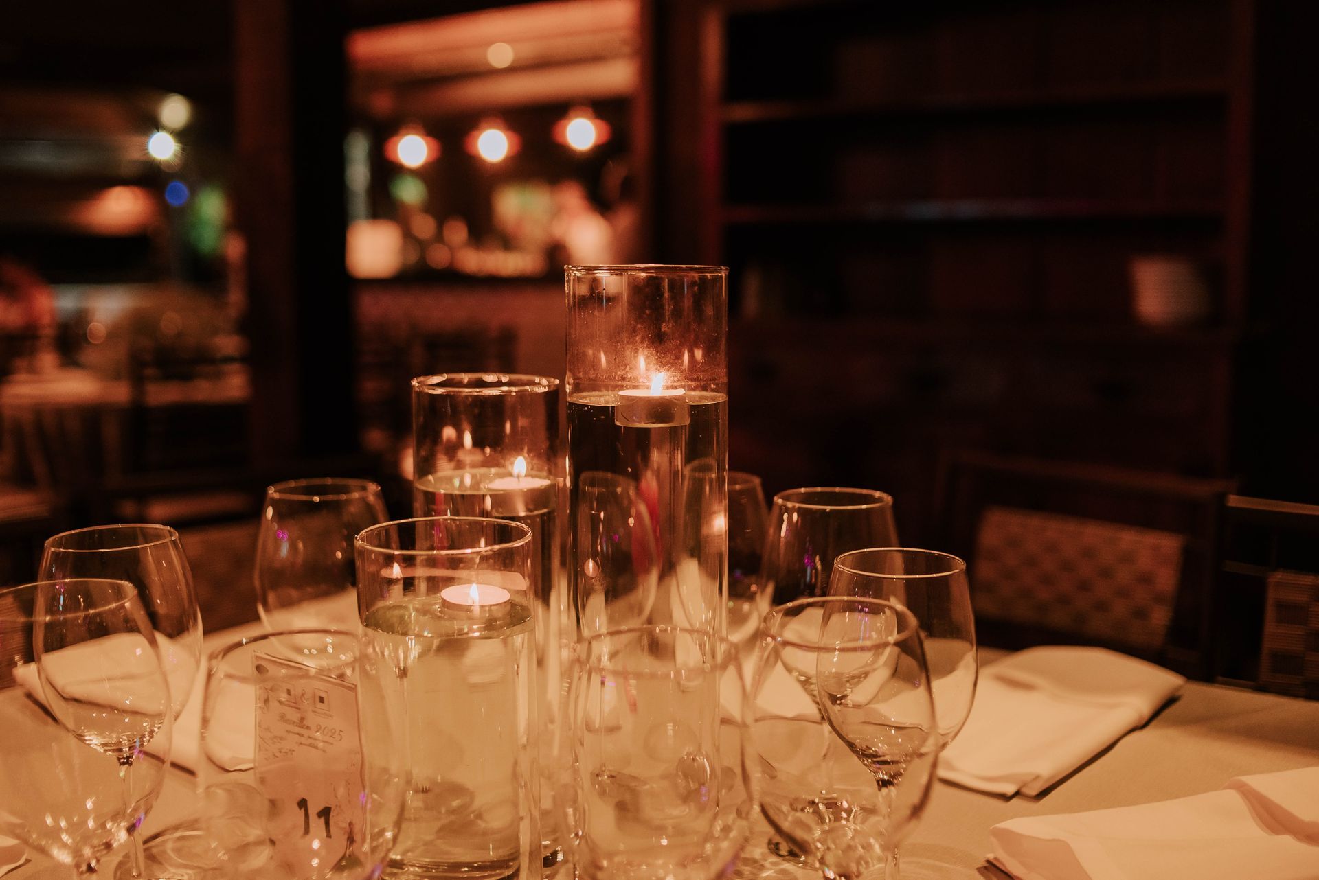 Uma mesa com taças de vinho e velas em um restaurante. Hotel Quadrado