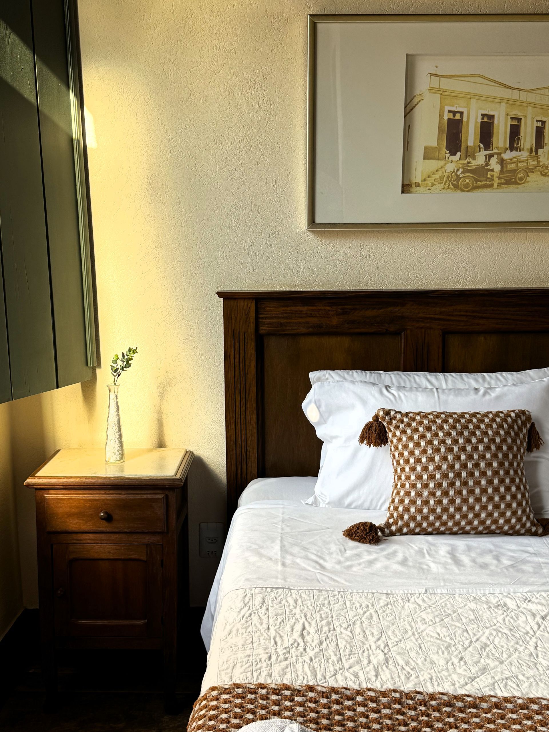 Uma cama com uma foto na parede acima dela. Hotel Quadrado