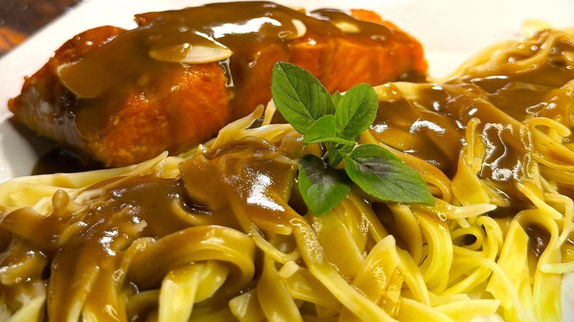 Um prato de macarrão com carne e molho por cima. Hotel Quadrado