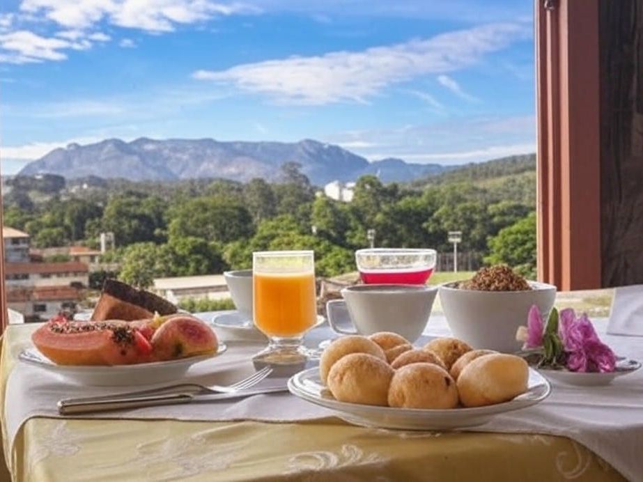 Um pátio com mesas, cadeiras e guarda-sóis em frente a um prédio. Hotel Quadrado