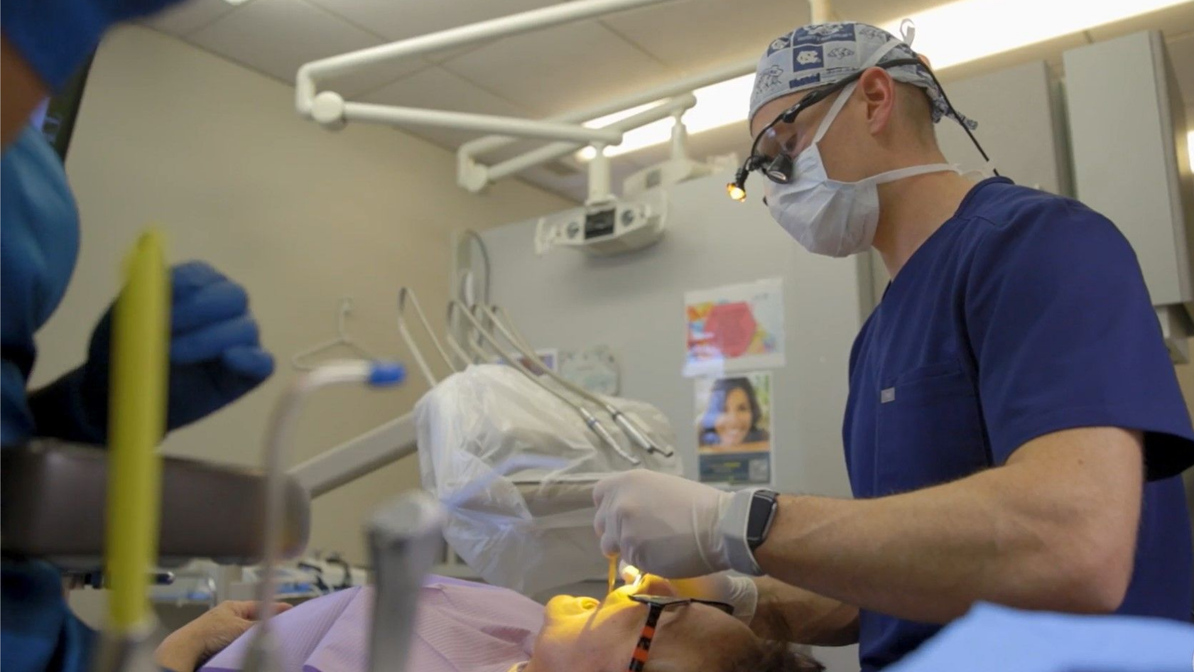 A dentist is examining a patient 's teeth in a dental office.