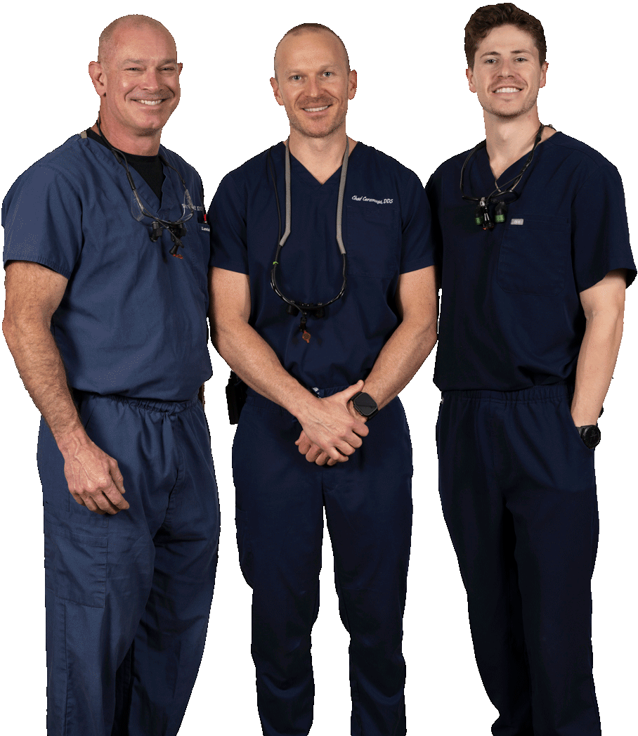 Three men in blue scrubs are posing for a picture
