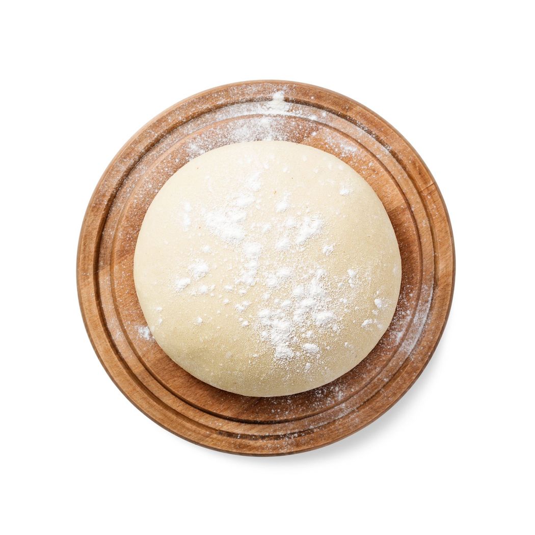 Piadina semplice con foglie di basilico e mezzo pomodoro su sfondo bianco.