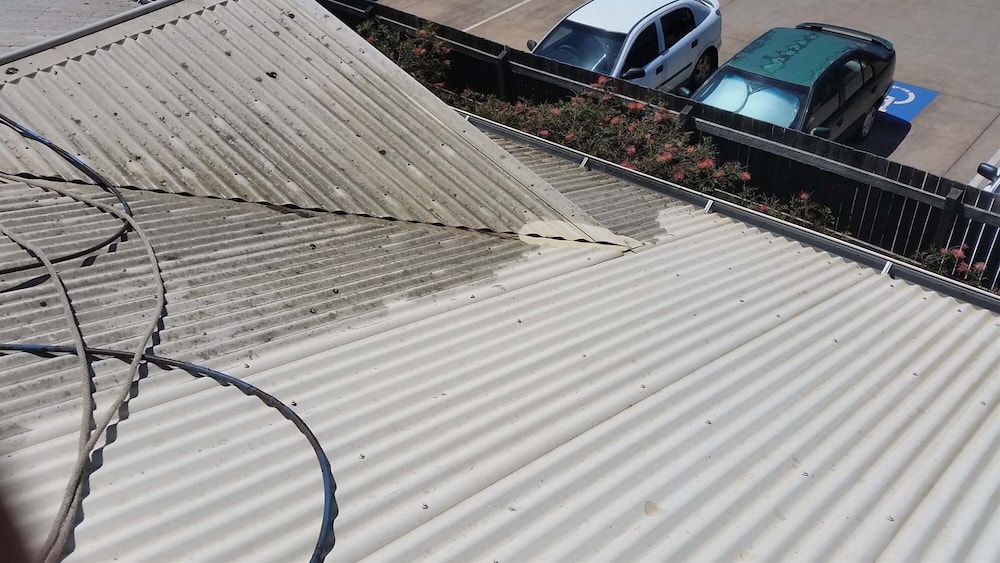 a Roof is Being Cleaned With a Hose in a Parking Lot — AD House Wash & Gutter Cover in East Toowoomba, QLD